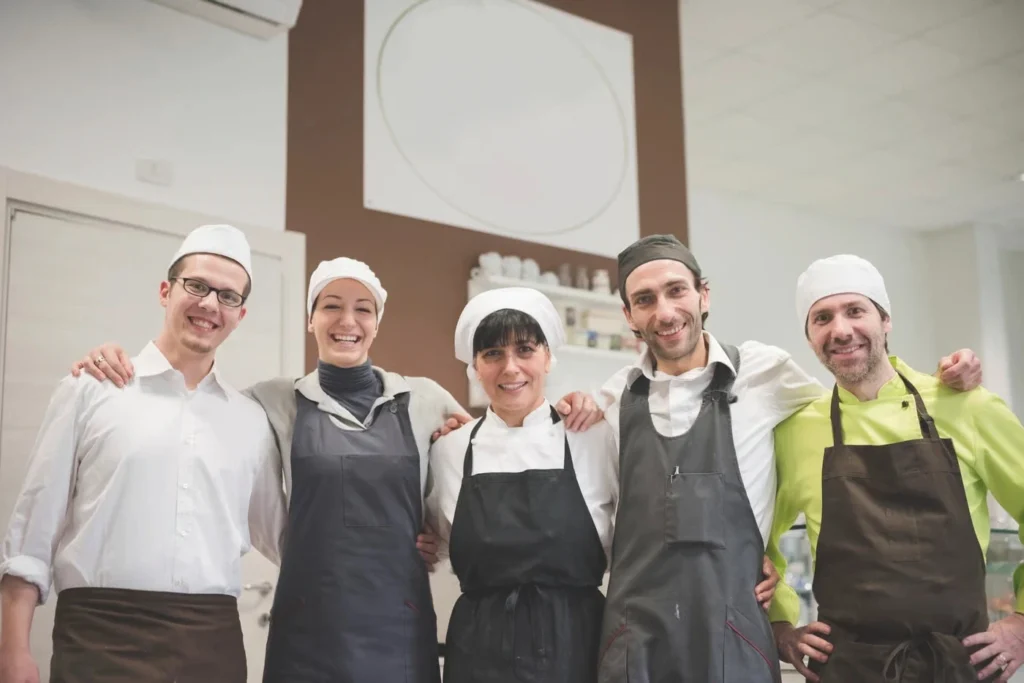 Emily Parker with her former culinary team, smiling together, showcasing the camaraderie of a professional kitchen.